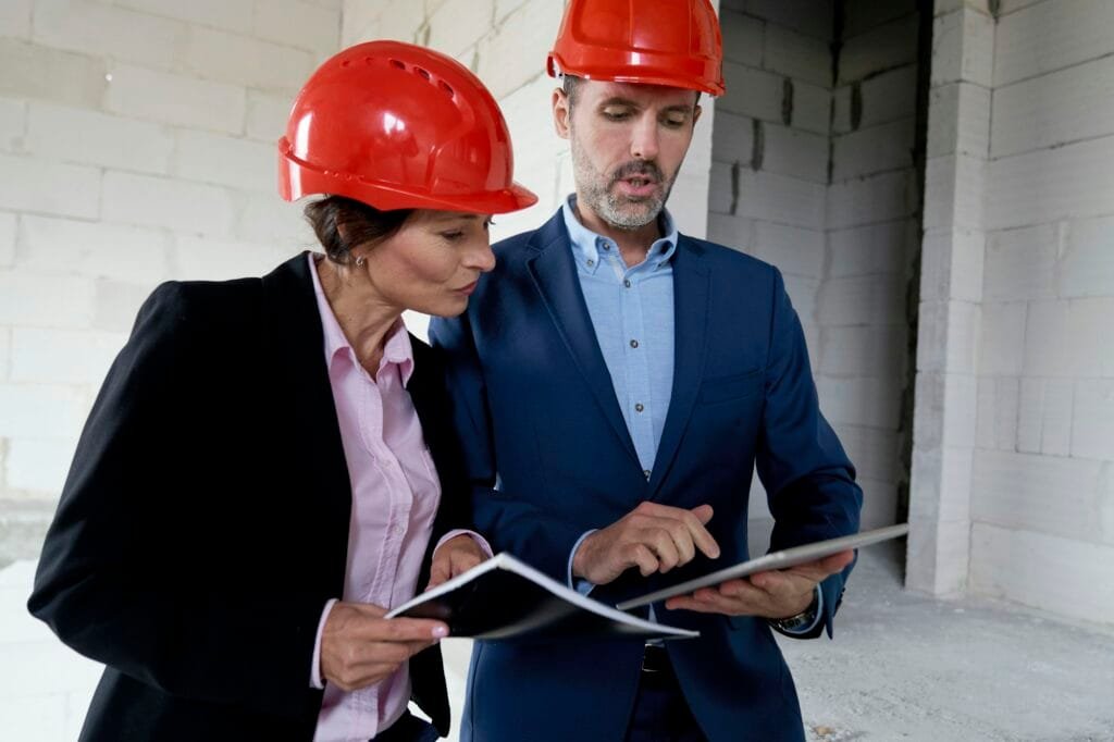 Two caucasian engineers and investors discussing on construction site